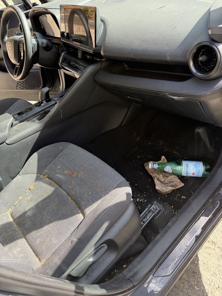 Toyota C-HR, place passager avant le nettoyage : bouteille, miettes et terre sur la moquette