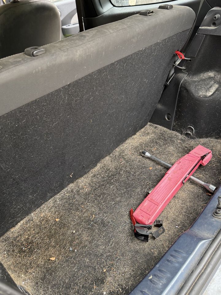 citadine Renault, coffre avant le nettoyage : moquette sale et objets