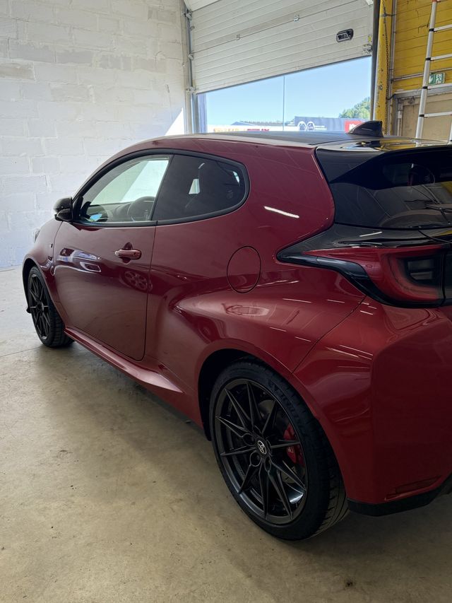 Toyota GR Yaris rouge vue de trois quarts arrière après lavage