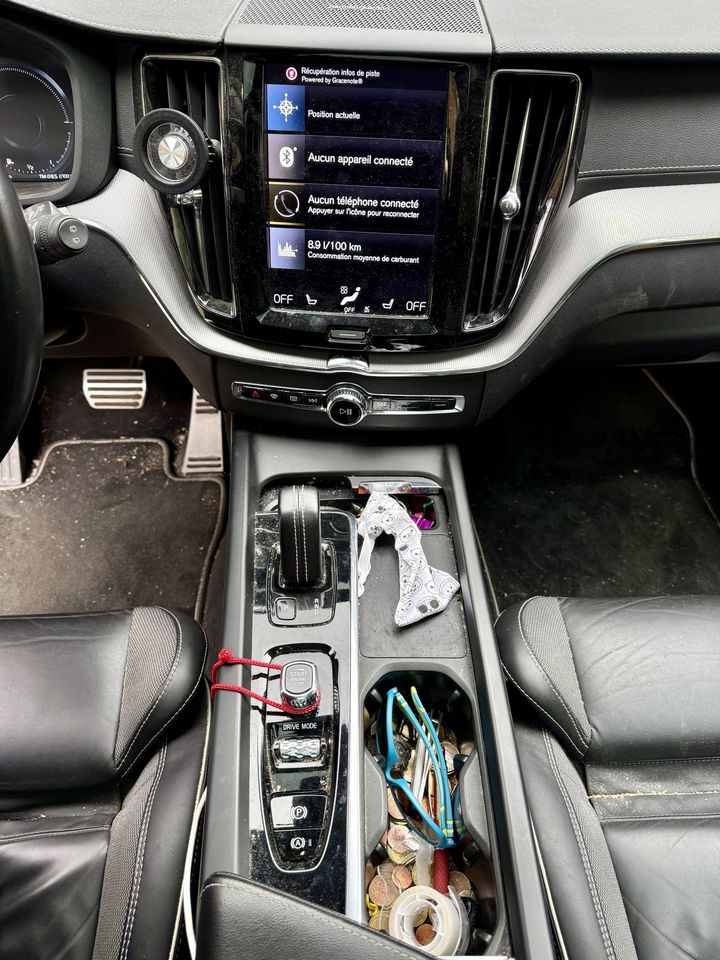 Volvo XC60, console centrale avant le nettoyage : console encombrée et poussiéreuse